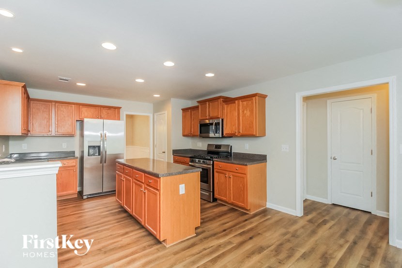 A kitchen with wooden cabinets and a refrigerator.