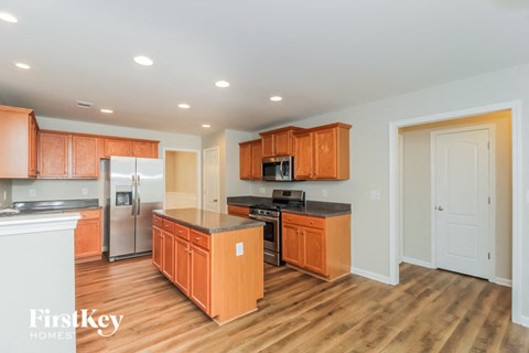 A kitchen with wooden cabinets and a refrigerator.