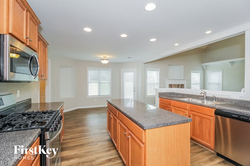 A kitchen with wooden cabinets and a granite countertop.