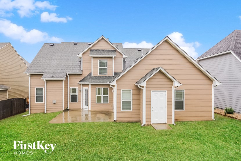 A house with a brown and beige exterior is for sale by FirstKey Homes.