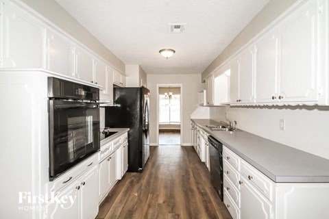 a renovated kitchen with white cabinets and black appliances
