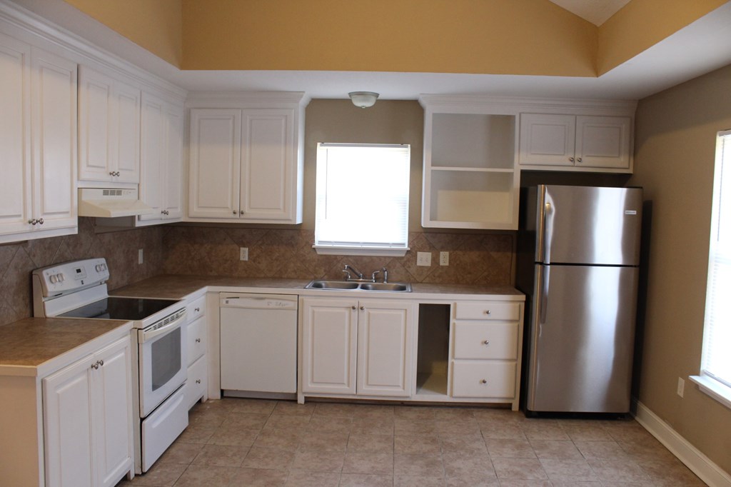 a kitchen with white cabinets and stainless steel appliances