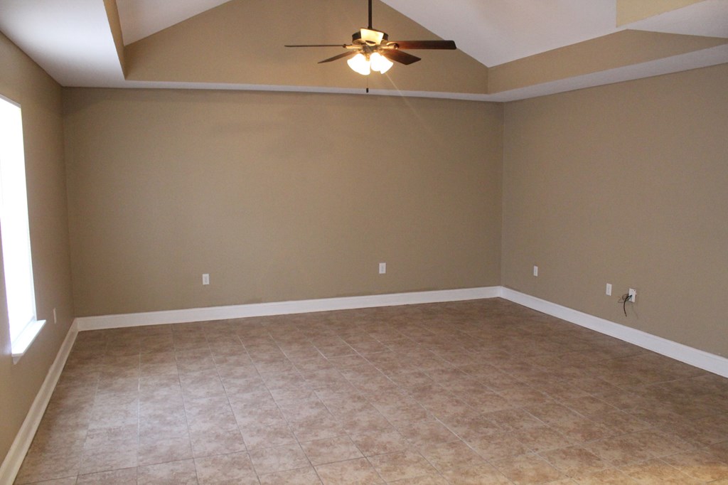 a empty living room with a ceiling fan