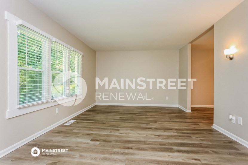 a living room with a large window and a wooden floor