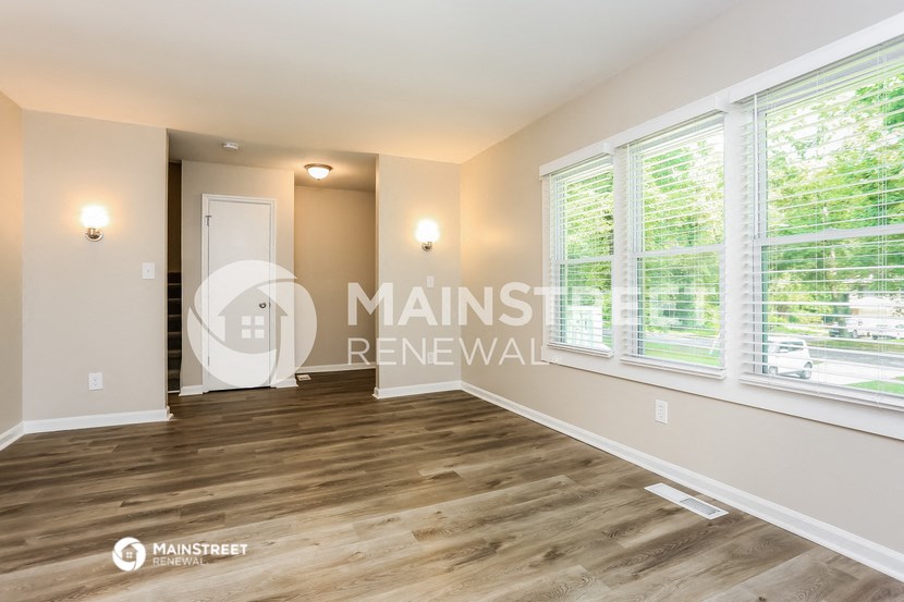 a living room with large windows and a white door