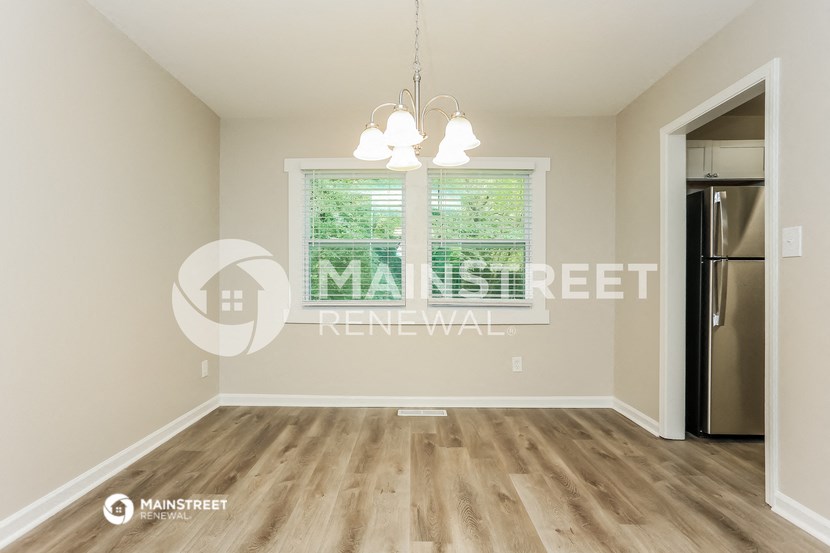 a living room with a large window and a refrigerator