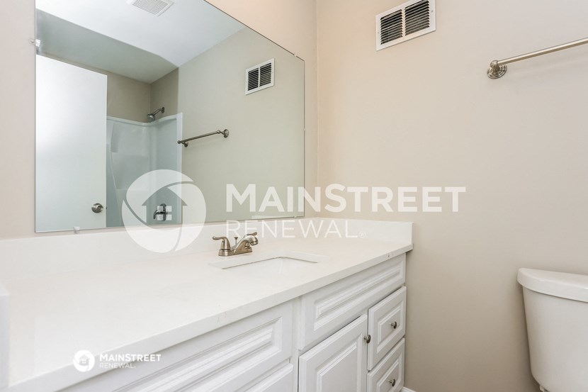 a white bathroom with a sink and a mirror