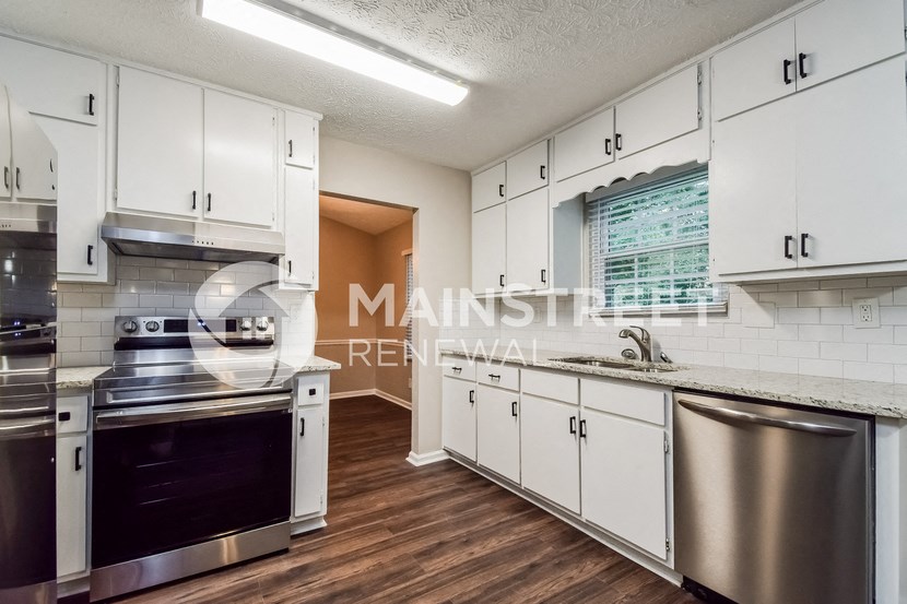 a kitchen with white cabinets and stainless steel appliances