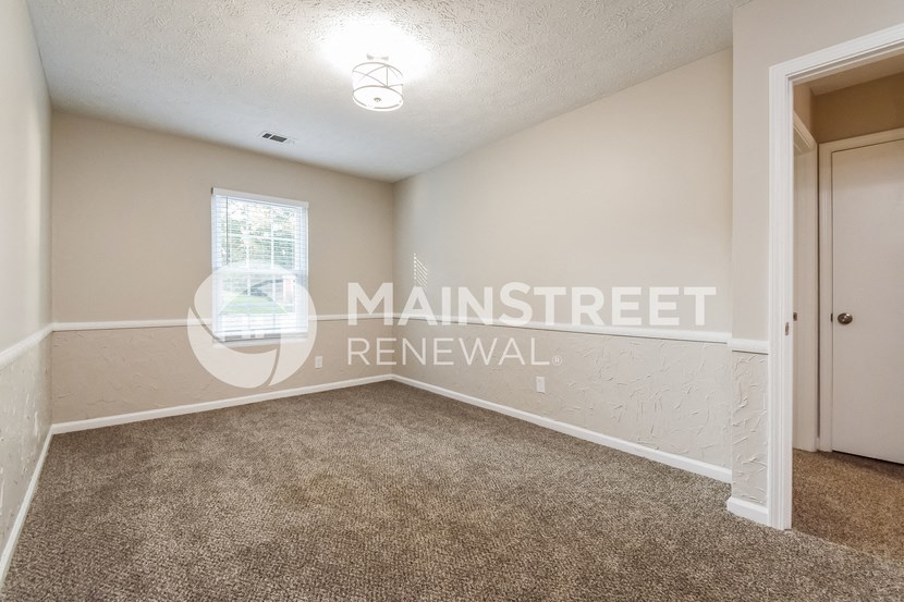 a bedroom with carpet and a door to a closet