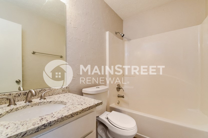 a bathroom with a sink and a toilet and a bath tub