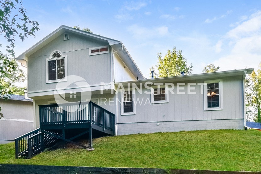 a large white house with a ramp and a green lawn