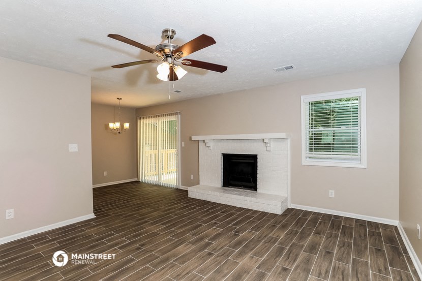 a living room with a fireplace and a ceiling fan
