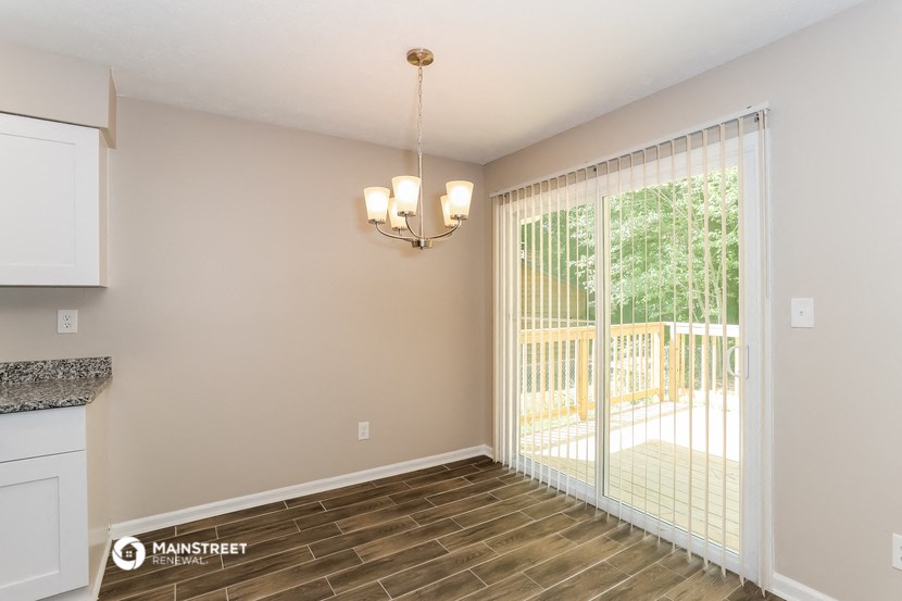 a living room with a sliding glass door to a balcony