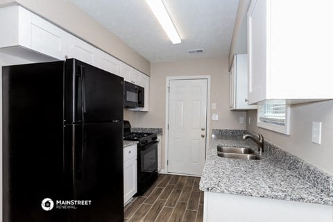 a kitchen with black appliances and granite counter tops