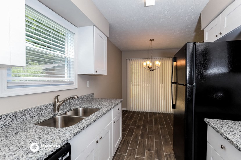 a kitchen with a sink and a refrigerator and a window