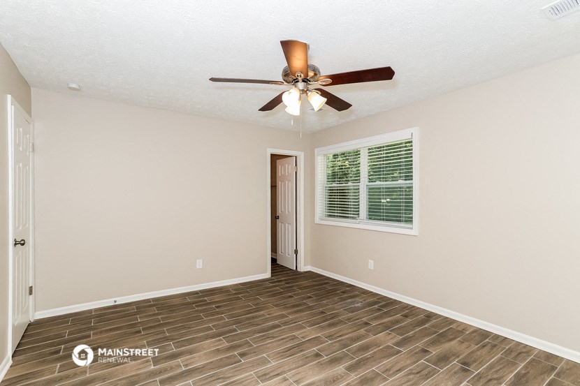 a living room with a ceiling fan and a window