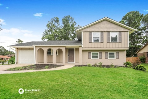 a beige house with a lawn in front of it