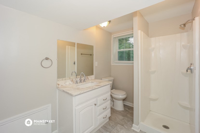 a bathroom with a toilet and a sink and a shower