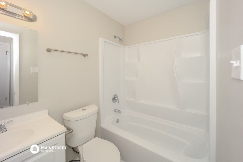 a bathroom with a tub and a sink and a toilet