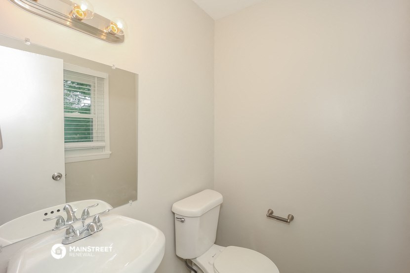 a bathroom with a toilet and a sink and a mirror