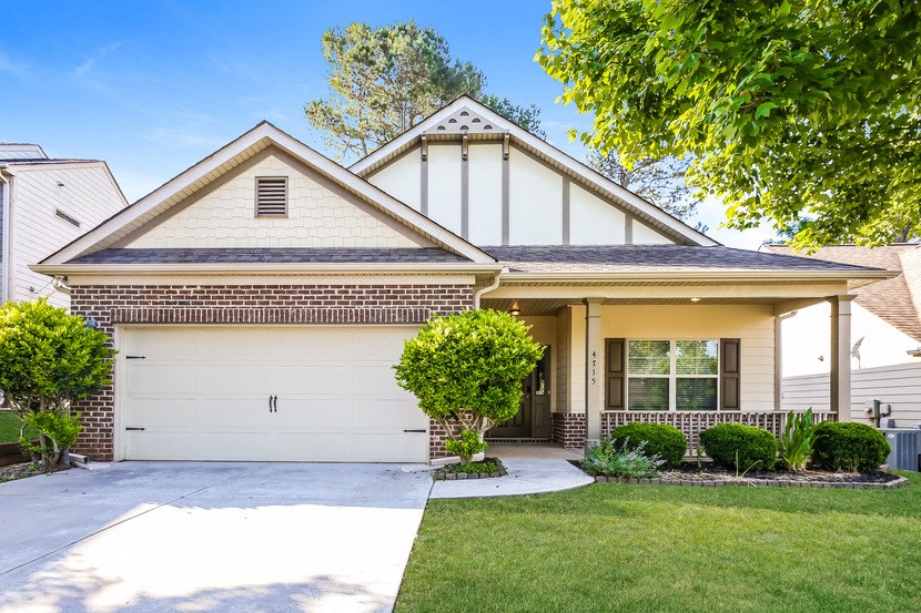 a house with a white garage door and a lawn