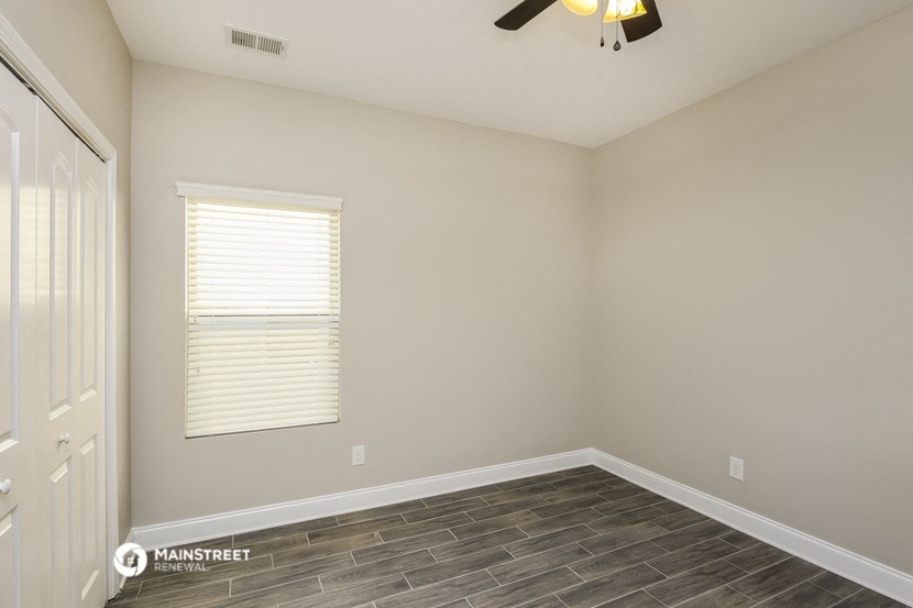 a empty room with a window and a ceiling fan