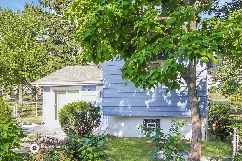 a small blue house with a tree in front of it