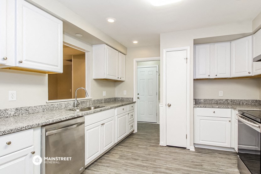 a kitchen with white cabinets and granite counter tops