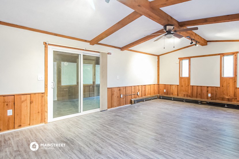 an empty room with wood floors and a sliding glass door