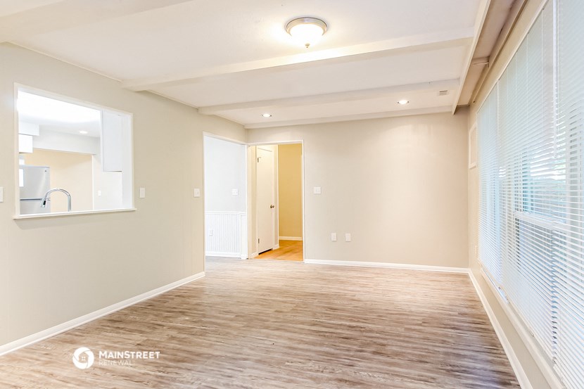 an empty living room with a wood floor and a window