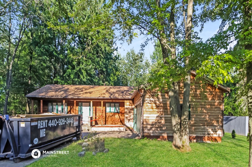 a small wooden cabin with a boat in front of it