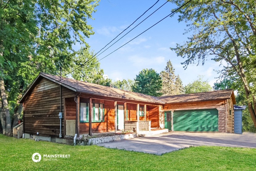 a log cabin with a green garage door