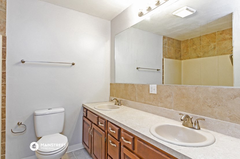 a bathroom with two sinks and a mirror and a toilet