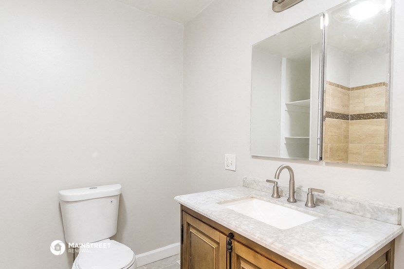 a bathroom with a toilet and a sink and a mirror