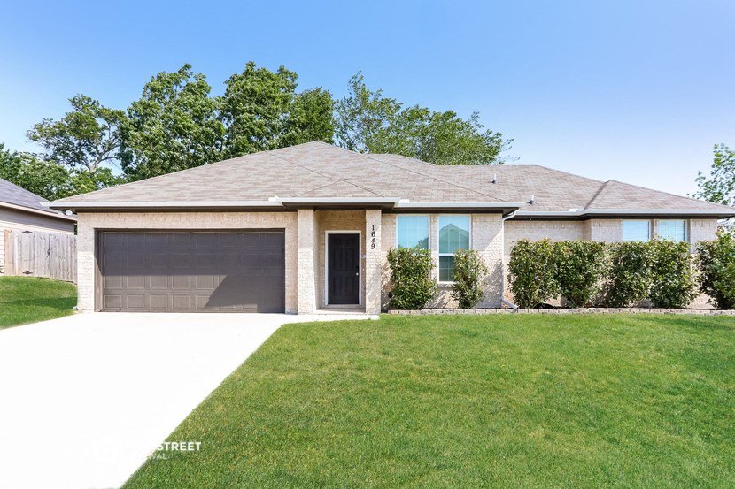 a house with a lawn and a garage door
