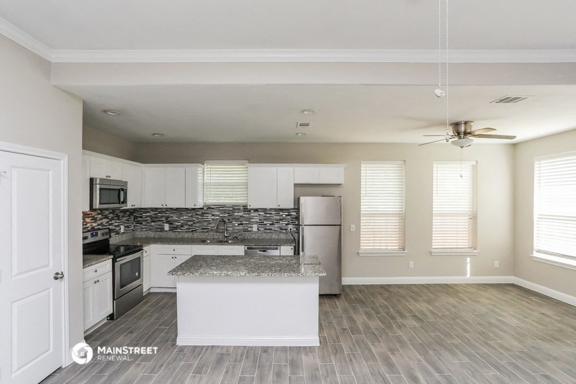 an empty kitchen with white cabinets and stainless steel appliances