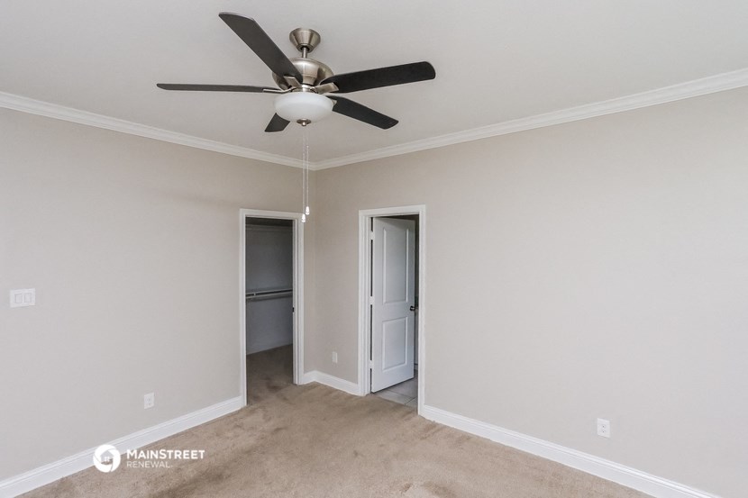 a empty room with a ceiling fan and a closet