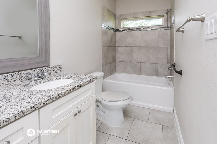 a bathroom with a toilet and a tub and a sink