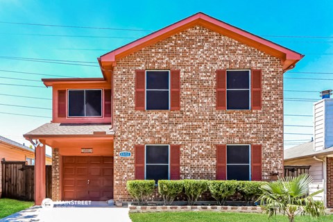 a small brick house with a lawn in front of it