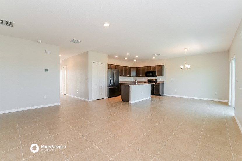 the spacious living room and kitchen with stainless steel appliances