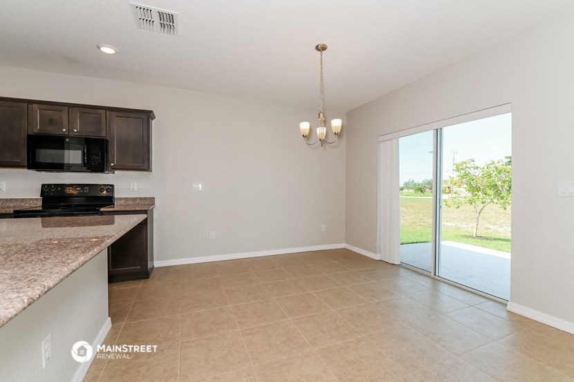 a kitchen and living room with a sliding glass door to a patio