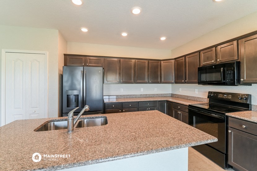 a kitchen with a granite counter top and black appliances