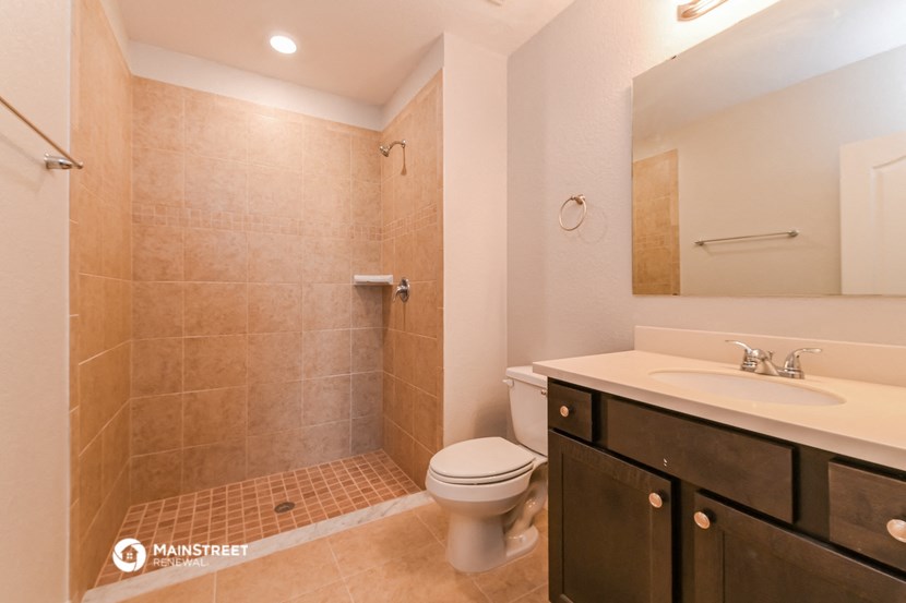 a bathroom with a toilet sink and shower and a mirror
