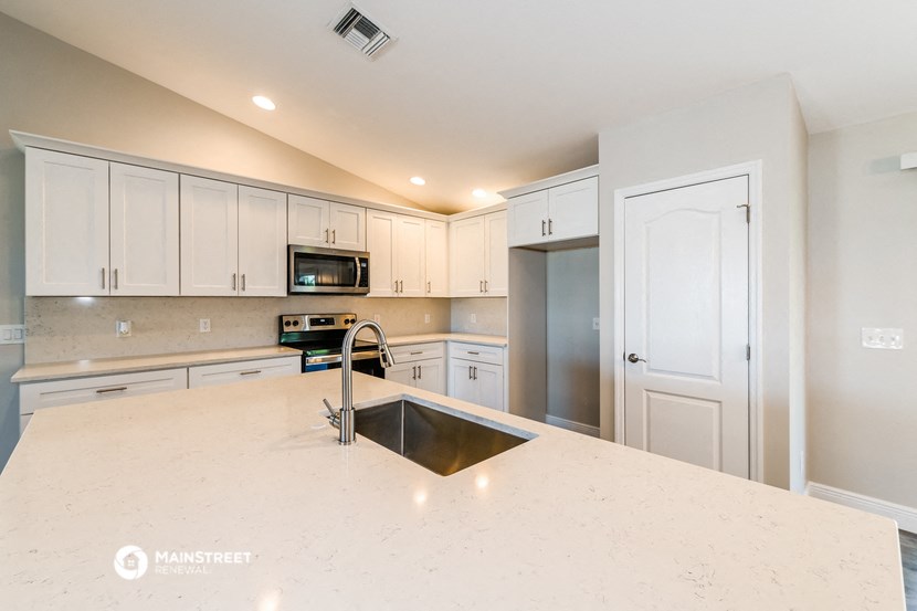 a kitchen with white cabinets and a white counter top