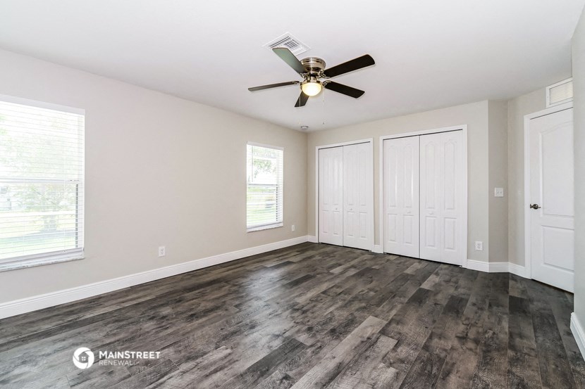 the living room of a home with a ceiling fan and white doors