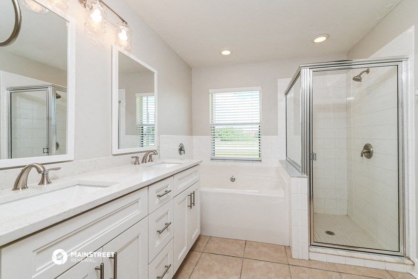 a white bathroom with two sinks and a shower