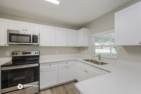 the kitchen of our studio apartment atrium with white cabinets and stainless steel appliances