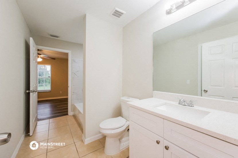 a bathroom with a toilet and a sink and a mirror