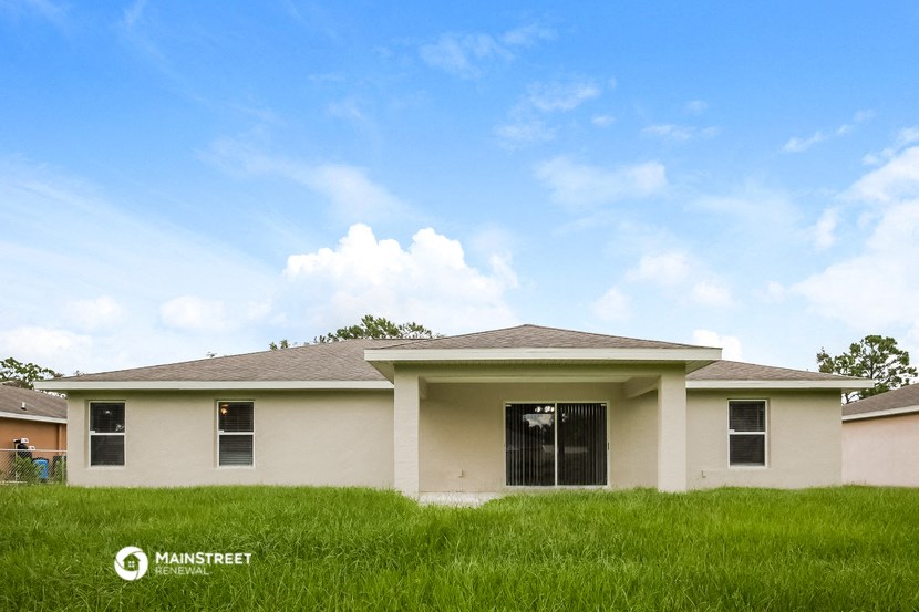 a house with a grassy yard and a blue sky