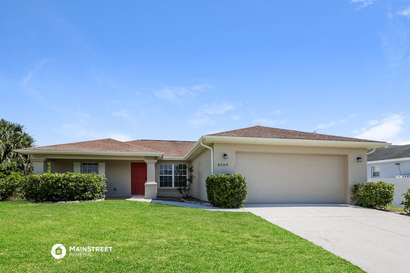 a white house with a lawn and a garage door